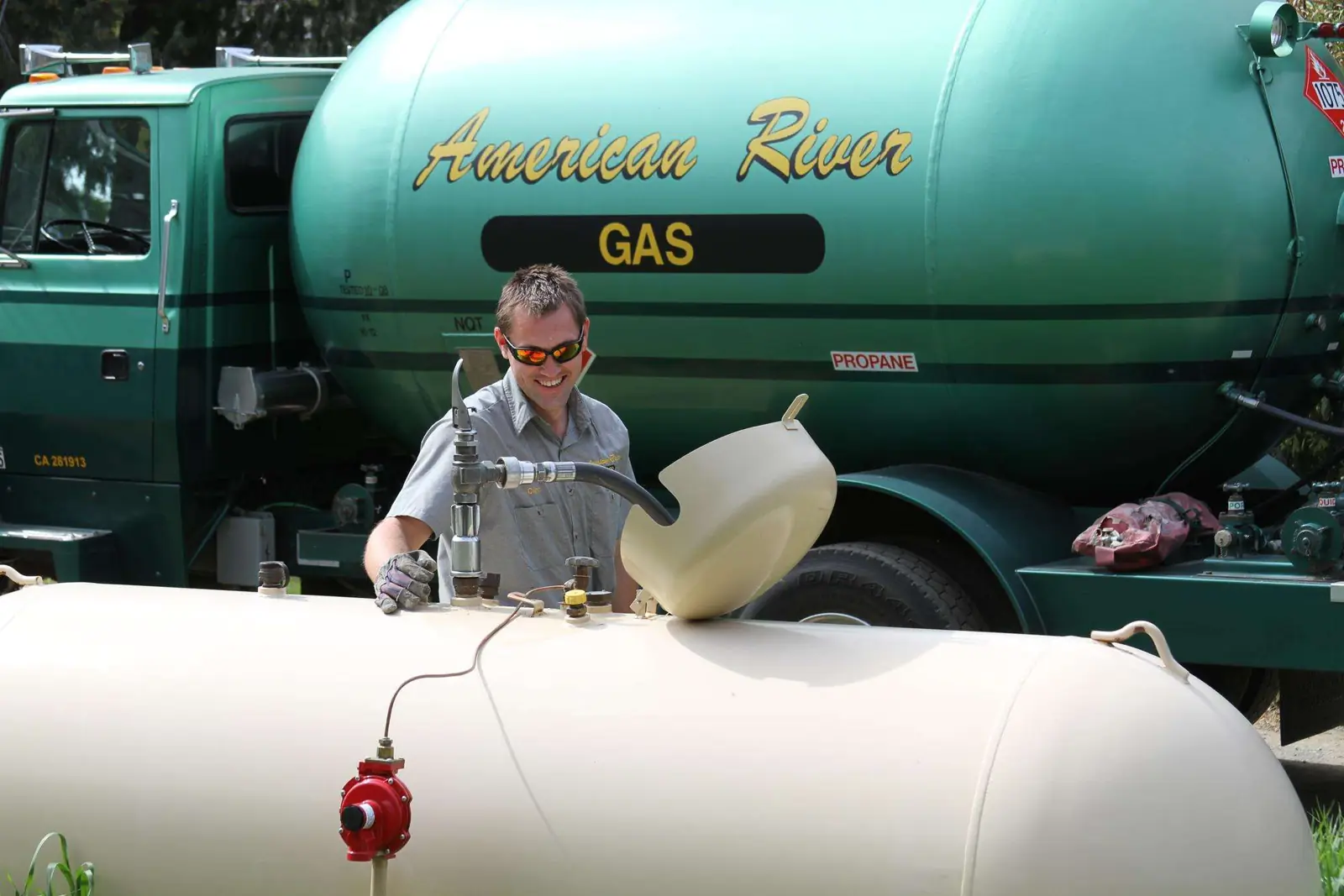 Driver connecting the delivery hose to a propane tank